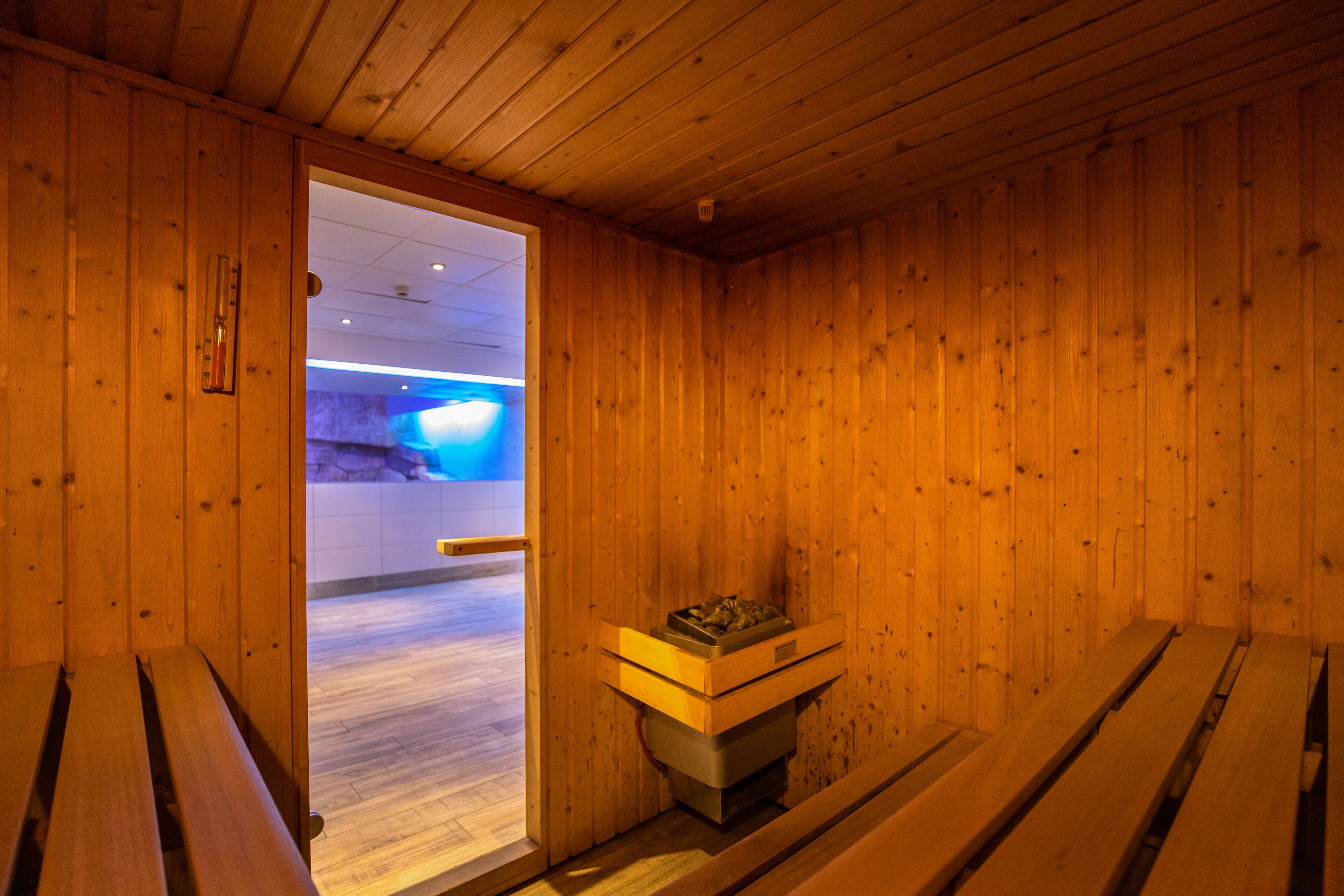 A sauna room with wooden walls and benches.