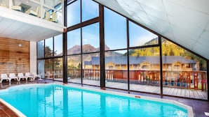 Piscina con vista a una montaña y un edificio de madera.