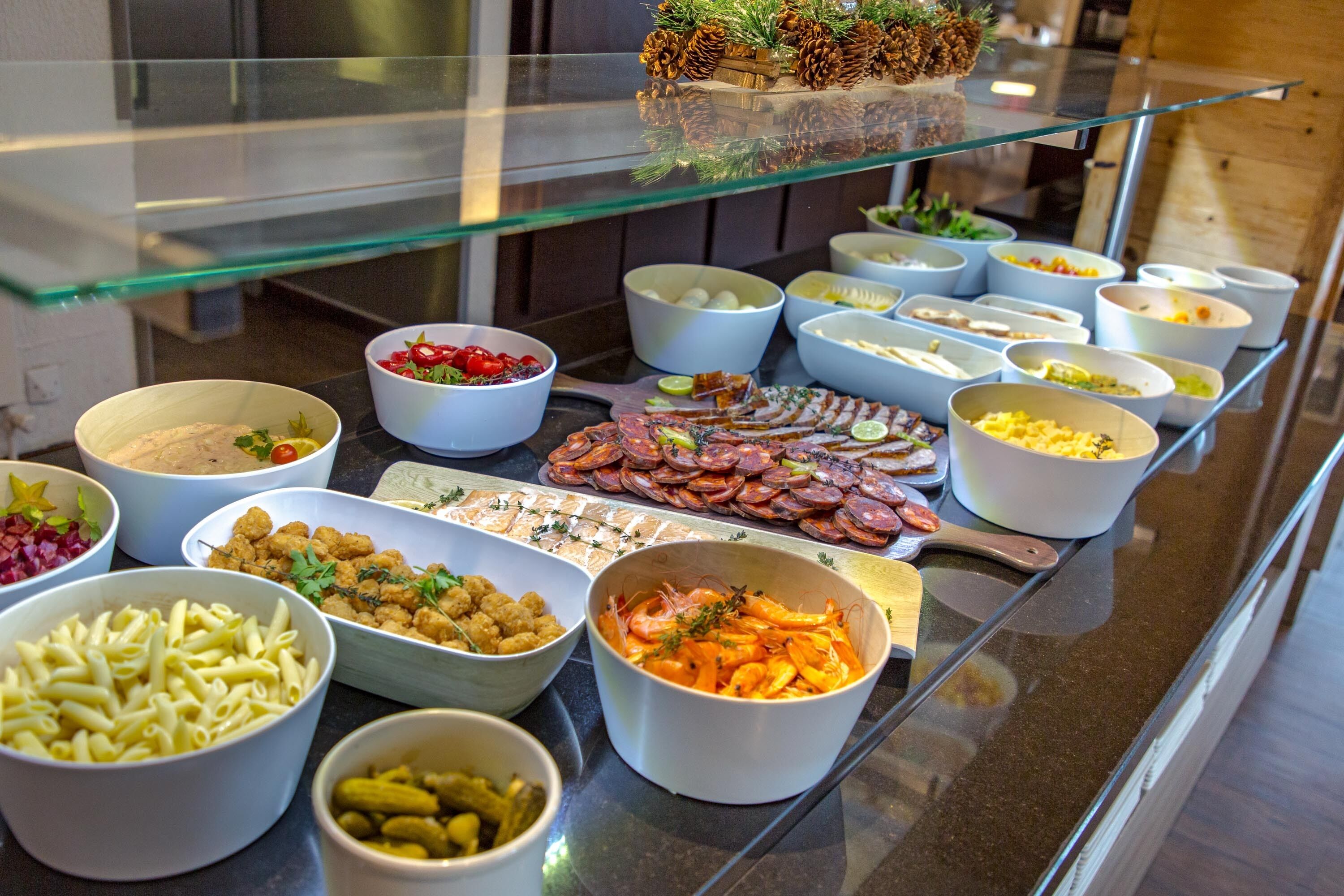 Ein Buffet mit verschiedenen Speisen, darunter Pasta, Meeresfrüchte und Salate.