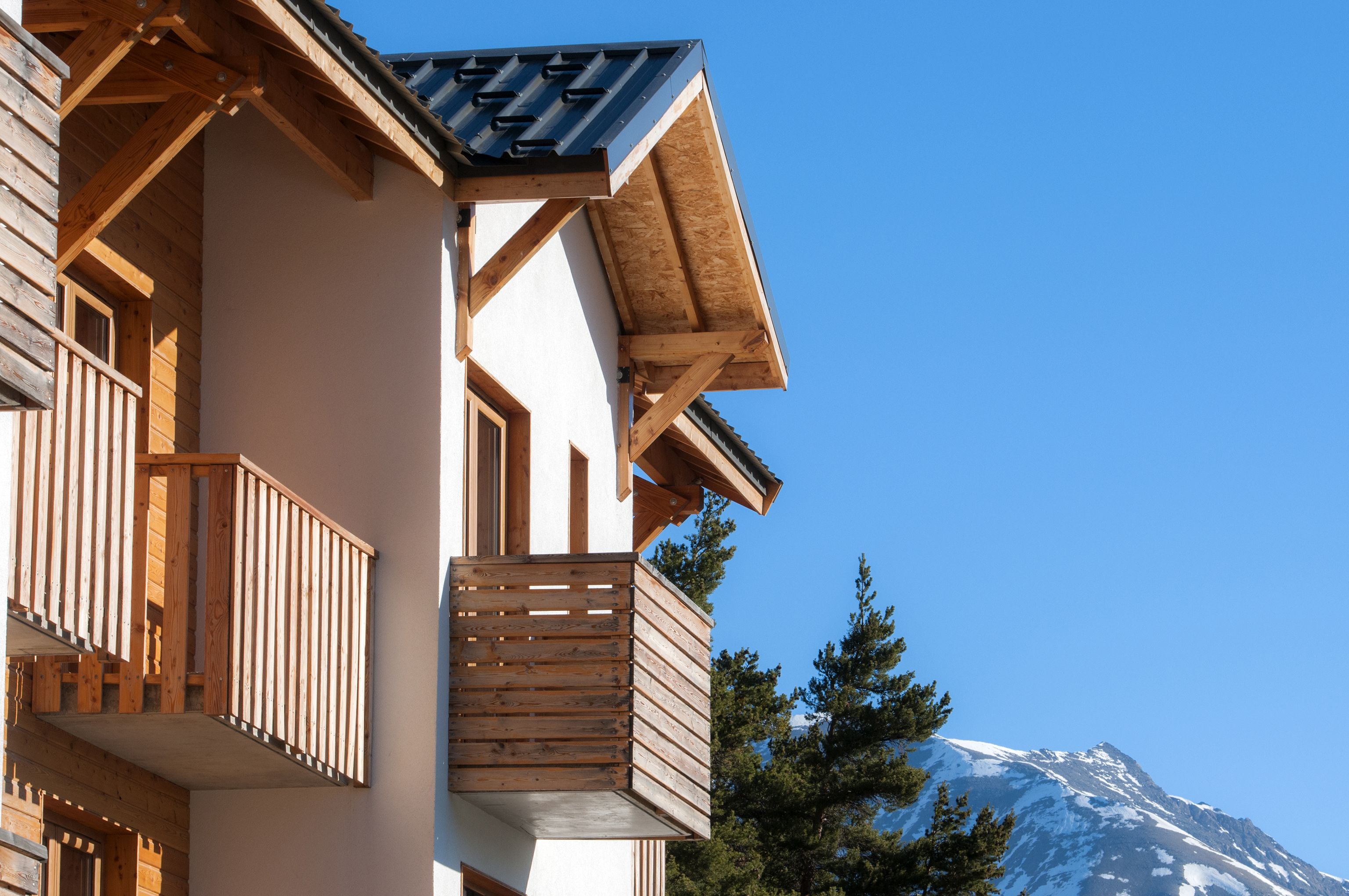 A wooden balcony with a view of a snow-capped mountain.
