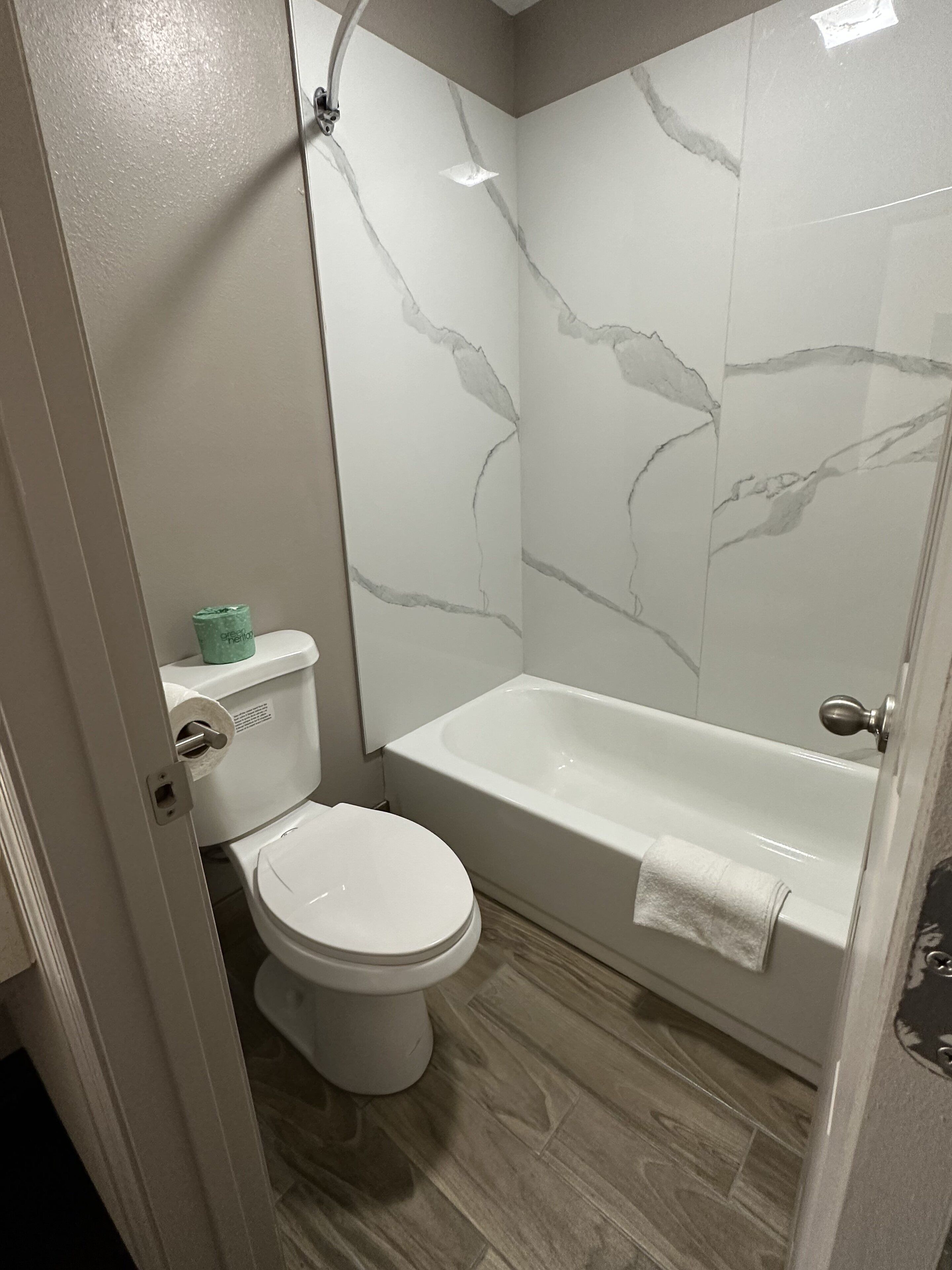 Een badkamer met toilet, bad en douche.