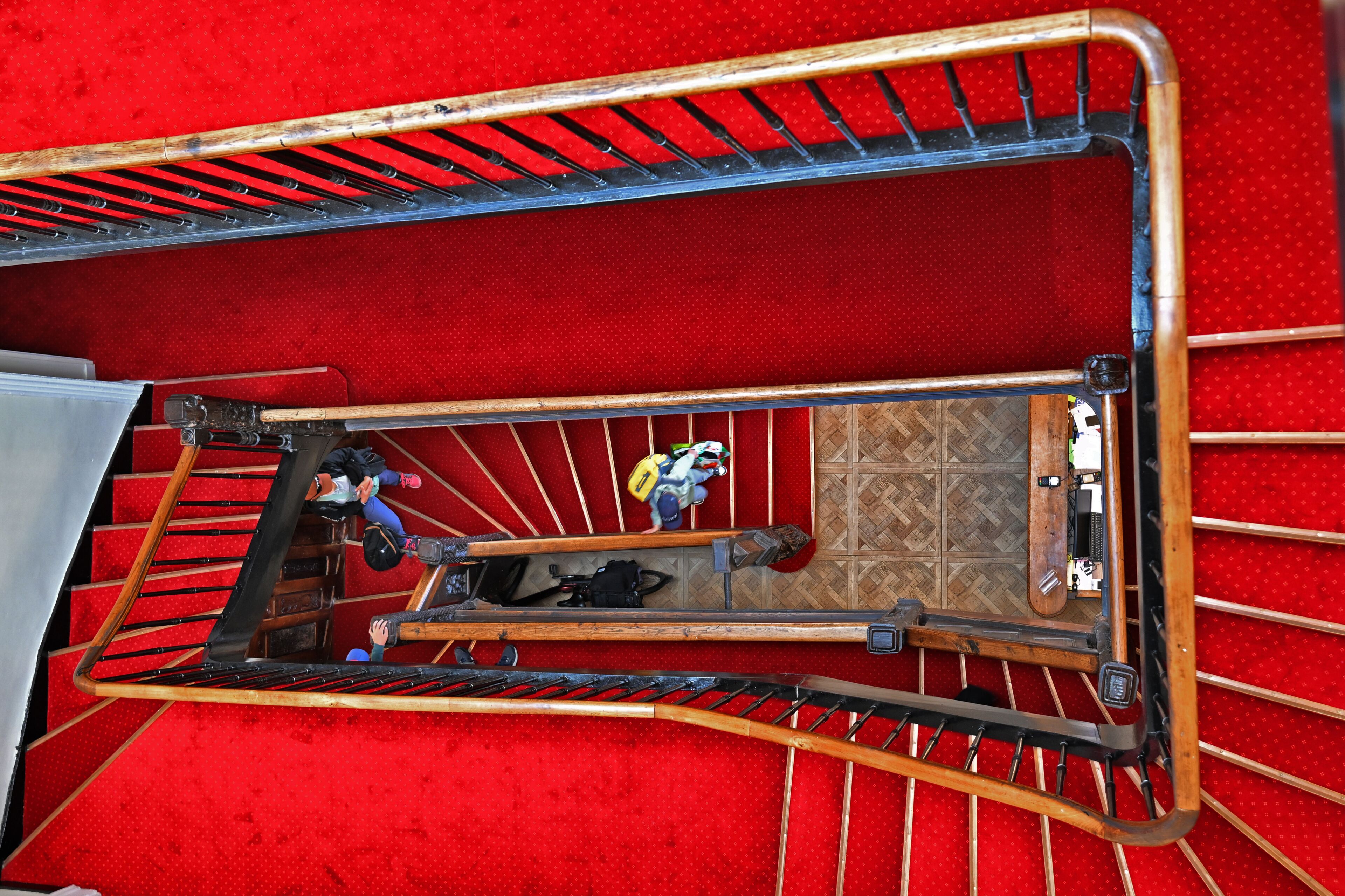 A red carpeted area with a metal staircase and a wooden handrail.