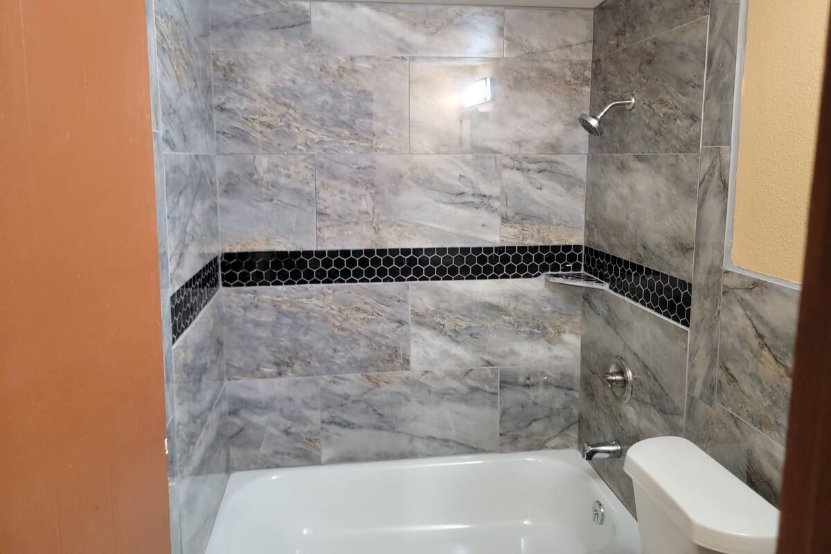 A bathroom with a bathtub, a shower, and a toilet.