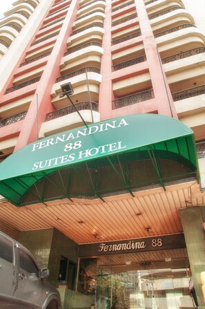 The exterior of the Fernandina 88 Suites Hotel, featuring a prominent green awning and a tall building facade with balconies. - Fernandina 88 Suites Hotel (QUEZON CITY)