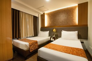 A hotel room with two beds, a nightstand, and a geometric-patterned wall. - Fernandina 88 Suites Hotel (QUEZON CITY)