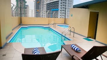 Relax by the rectangular pool surrounded by a tiled deck and lounge chairs.