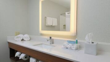 Une salle de bain avec un lavabo blanc, un miroir et un porte-serviettes.