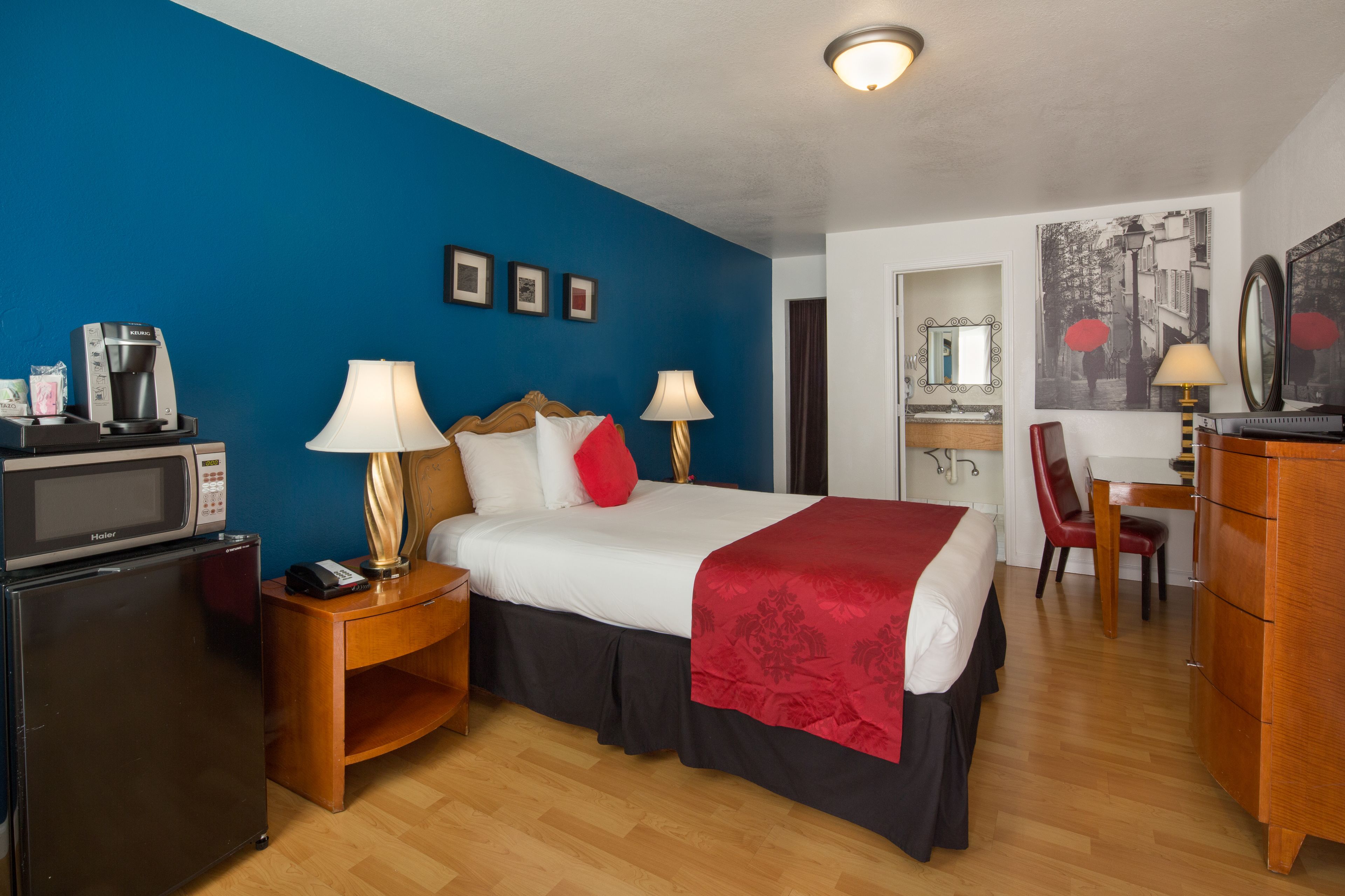 Une chambre d’hôtel équipée d’un lit, d’un bureau, d’une chaise, d’un four à micro-ondes, d’un réfrigérateur et d’une lampe.