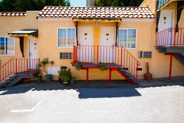 A building with a red staircase, two doors, and a small balcony.