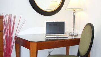Un pequeño espacio de oficina con un escritorio, una silla, una lámpara y un reloj en la pared.