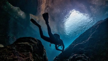 Un buceador en una cueva con formaciones rocosas naturales y agua.