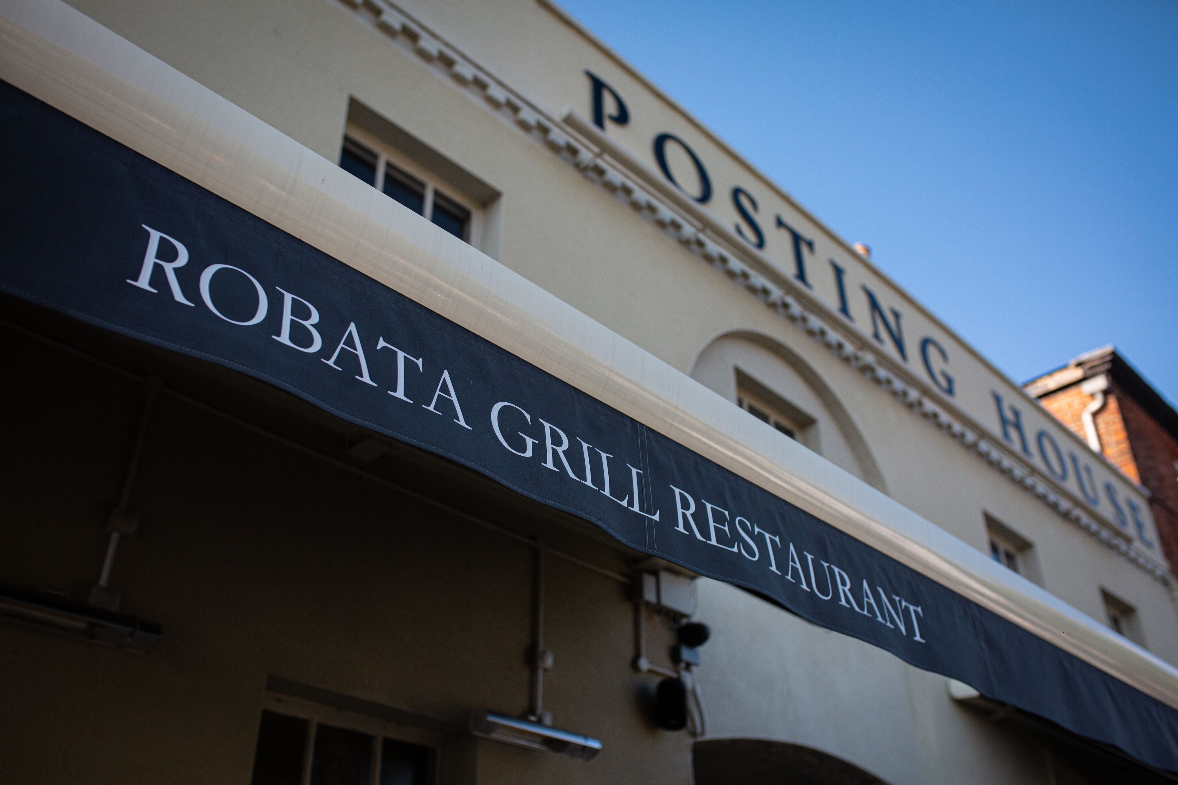 Un edificio con un letrero que dice "Robata Grill Restaurant" y "Posting House".