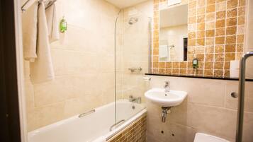 A bathroom with a glass-enclosed shower, a white sink, and a toilet.
