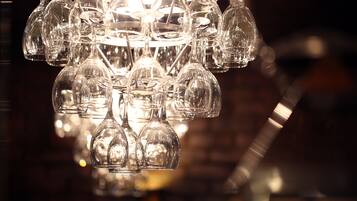 A chandelier with multiple clear glass wine glasses hanging from it.