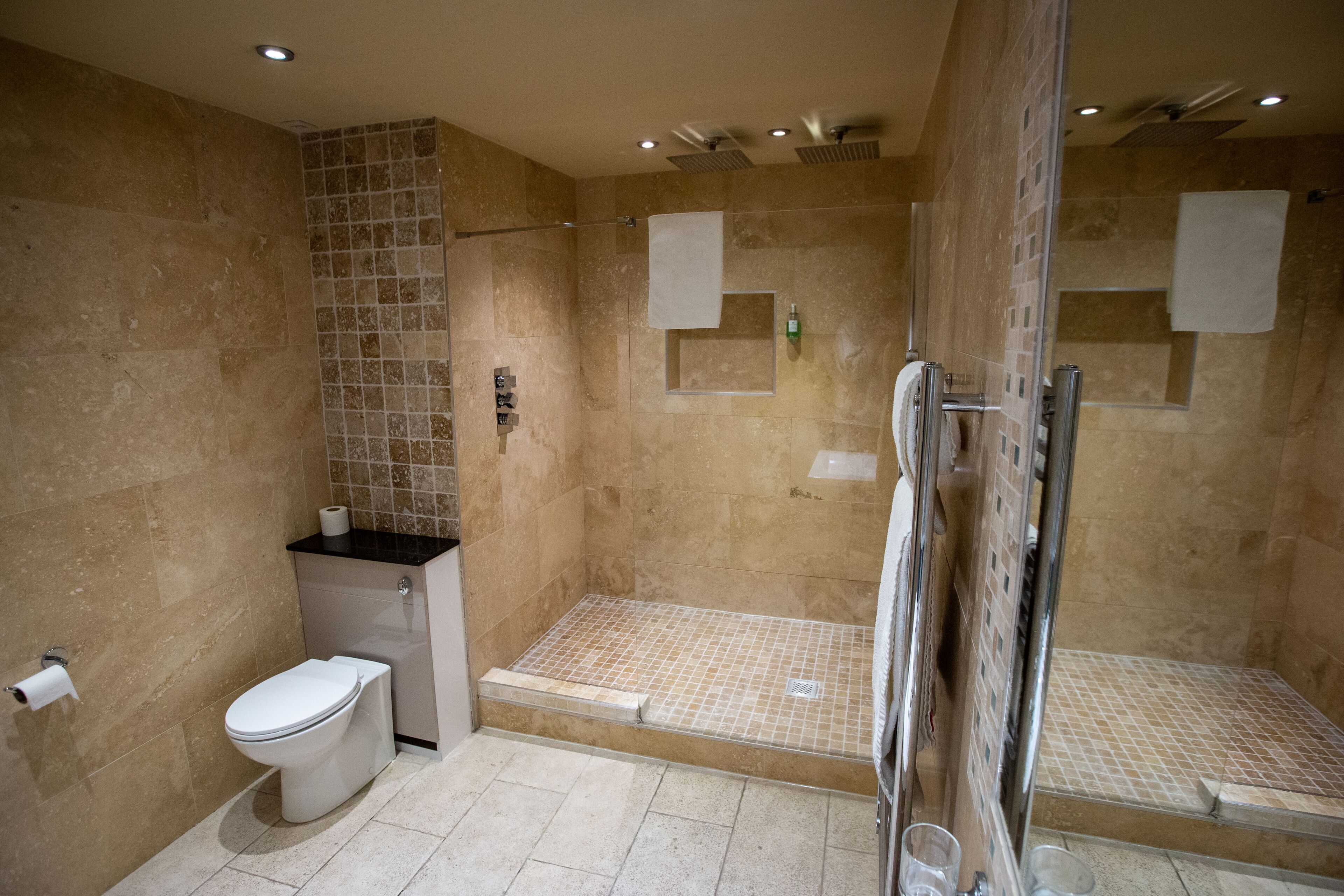 A modern bathroom with a shower, toilet, and sink.