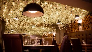 A restaurant interior with a floral ceiling, wooden log wall, and leather seating. - The Crown Hotel Bawtry, Doncaster (Doncaster)
