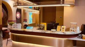 A hotel reception area with a marble counter, a no-smoking sign, a breakfast sign, and a sign for airport taxi services. - De Pijp Boutique Hotel (Amsterdam)