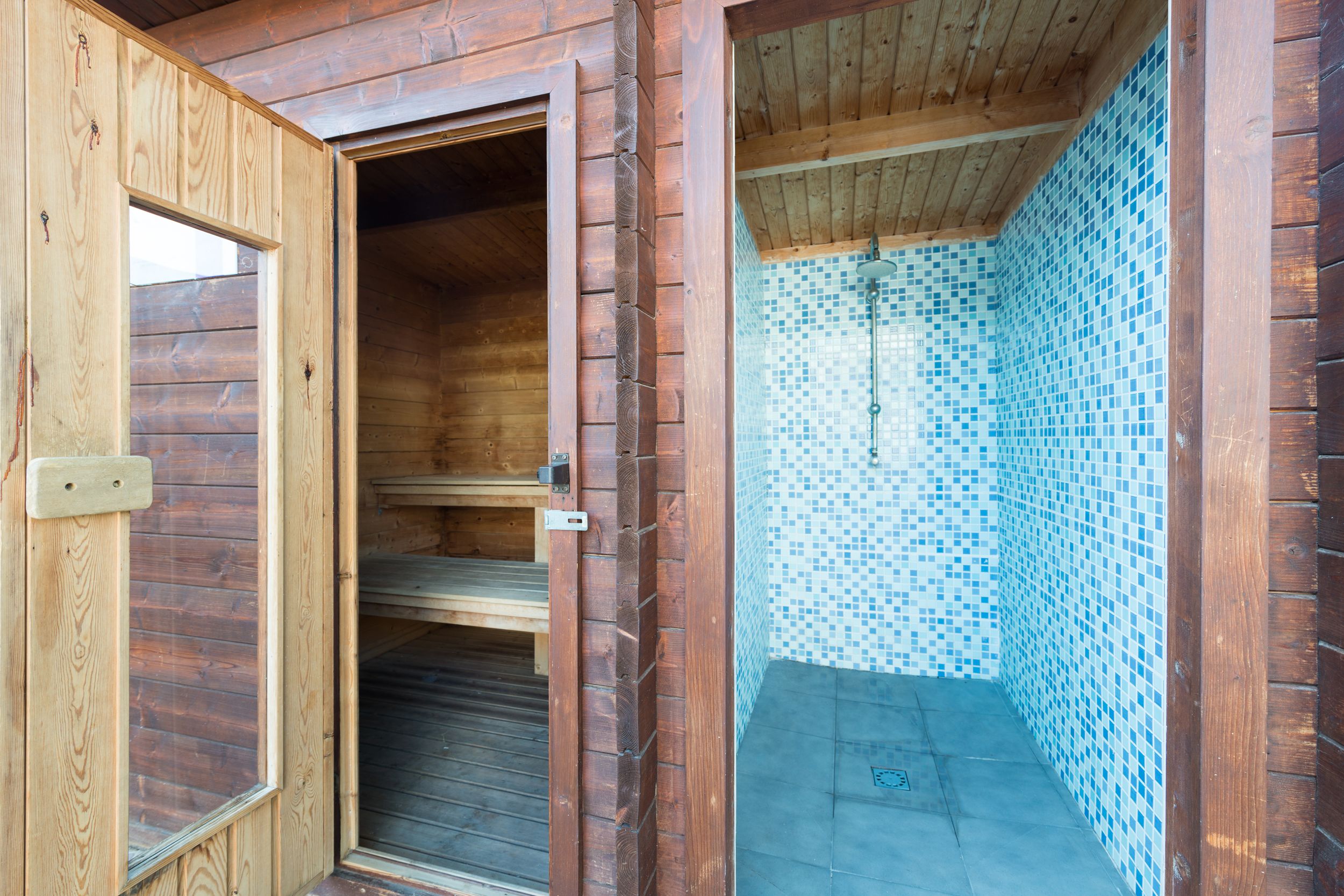 A wooden cabin with a tiled shower area.