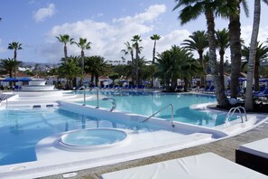 A pool area with lounge chairs and palm trees. - eó Suite Hotel Jardin Dorado (San Bartolomé de Tirajana)
