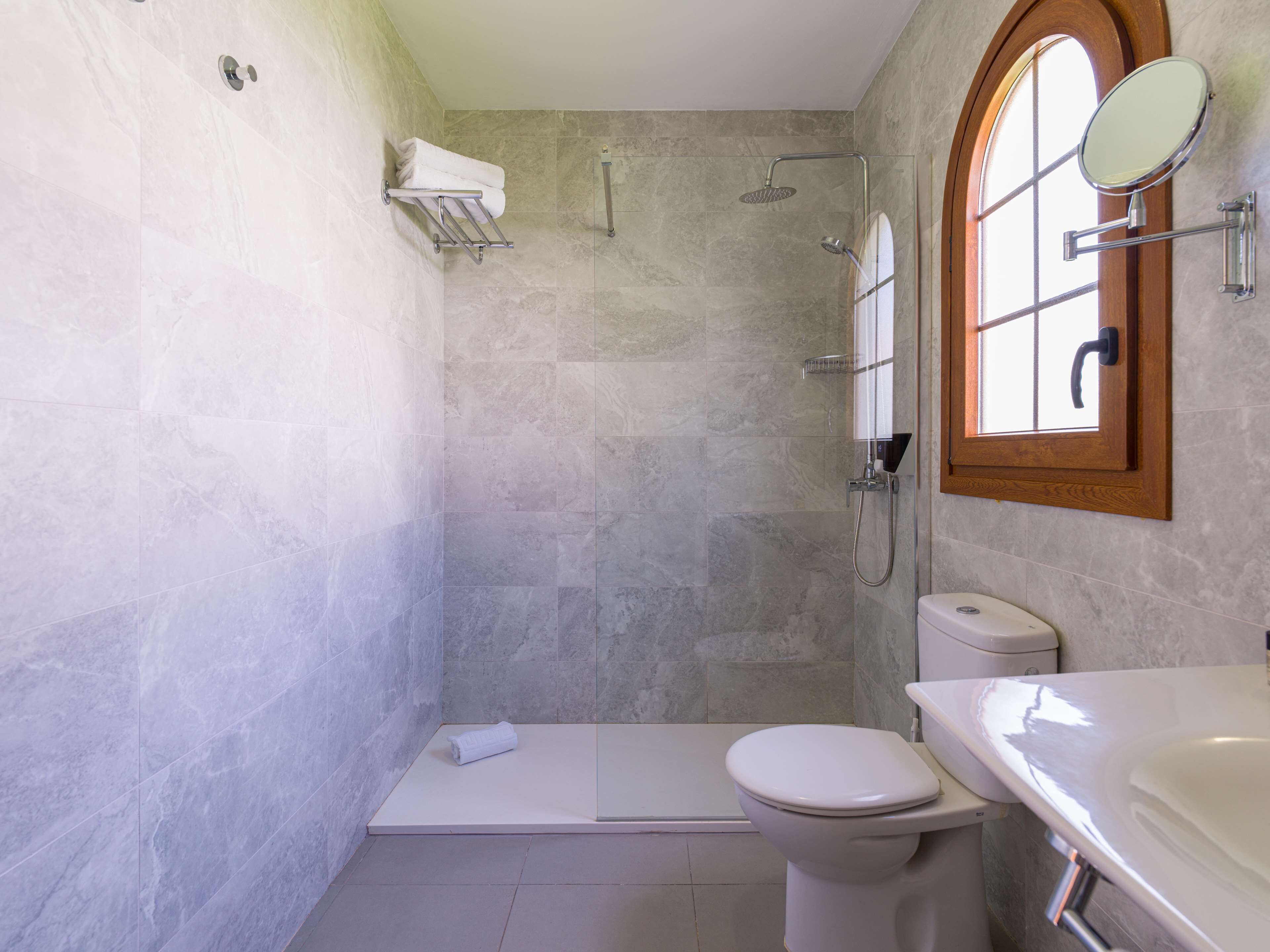 Een badkamer met douche, toilet en wastafel.