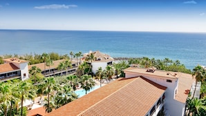 Un resort con varias edificaciones, una piscina y vista al océano.