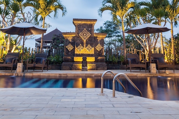 Una piscina al aire libre, camas de piscina gratis, sombrillas