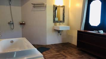 Ein Badezimmer mit Badewanne, Waschbecken, Spiegel und Dusche.