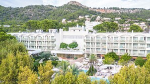 A hotel with multiple balconies, a swimming pool, and a mountainous backdrop. - Canyamel Park Hotel & Spa - Adults Only (Capdepera)