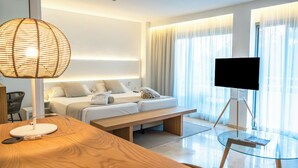 A modern hotel room with a bed, bedside table, lamp, TV, and a glass table with a chair. - Canyamel Park Hotel & Spa - Adults Only (Capdepera)