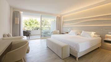 A modern hotel room with a large bed, a desk, and a balcony with outdoor seating.