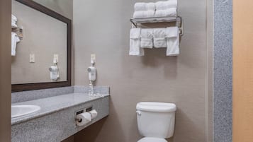 Un baño con lavabo, inodoro, toallero y espejo.