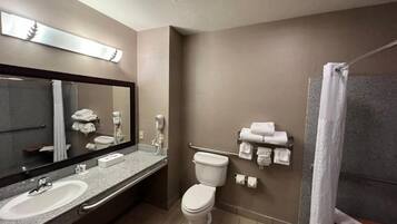 A bathroom with two sinks, a toilet, a shower, and a towel rack.