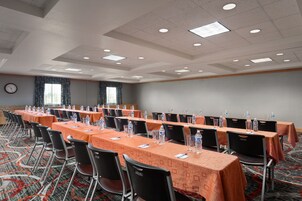 A conference room with long tables, chairs, and water bottles.