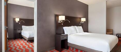 A hotel room with a bed, nightstands, and a mirror.