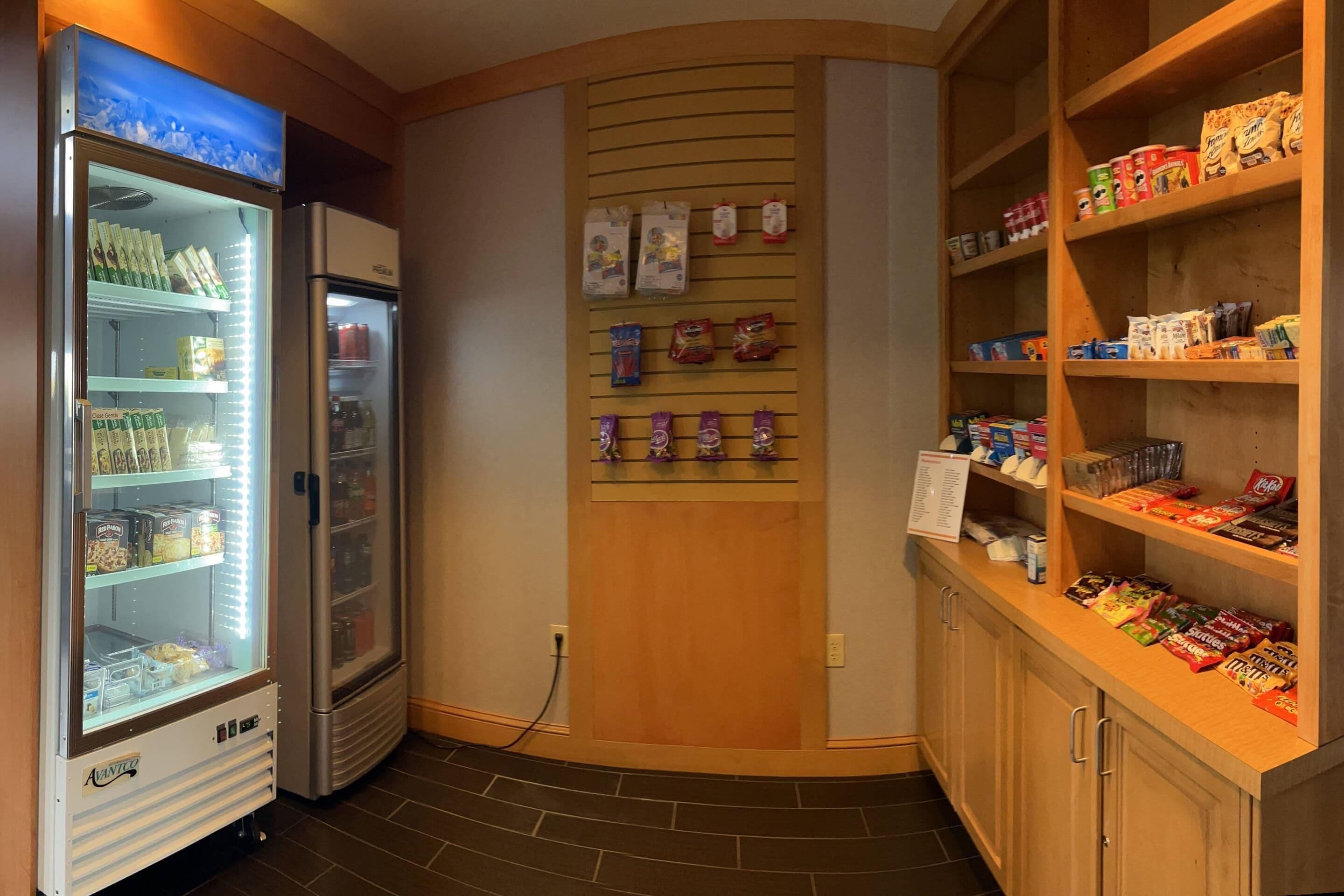 Distributore automatico, frigorifero e esposizione di snack in una camera d'albergo.