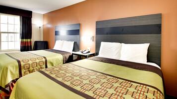 A hotel room with two beds, a desk, and a chair.