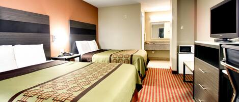 Une chambre d’hôtel avec deux lits, une télévision, un bureau et une salle de bain que l’on aperçoit à l’arrière-plan.