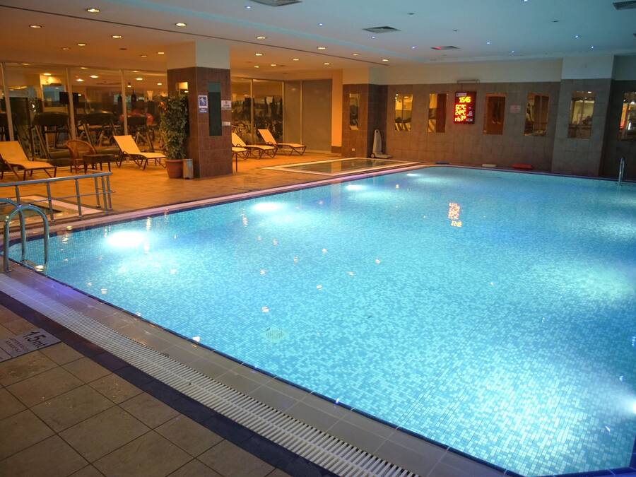 Una piscina techada, sillones reclinables de piscina