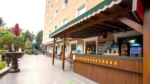 Un espace bar extérieur doté d’un comptoir en bois et de sièges.