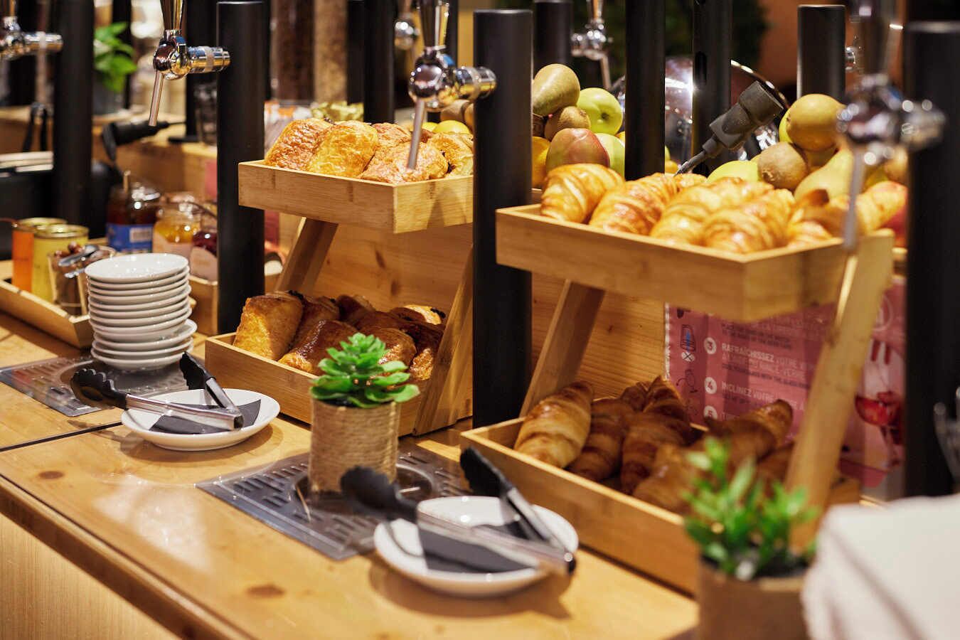 Ein reichhaltiges Frühstücksbuffet mit verschiedenen Backwaren, Früchten und Beilagen.