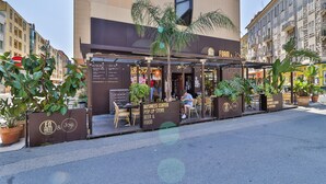 Um centro de negócios com área externa para sentar, uma loja temporária e um letreiro para um local de cerveja e comida.