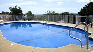 Ein Freibad mit Metallgeländer, umzäunt und mit Stühlen ausgestattet.