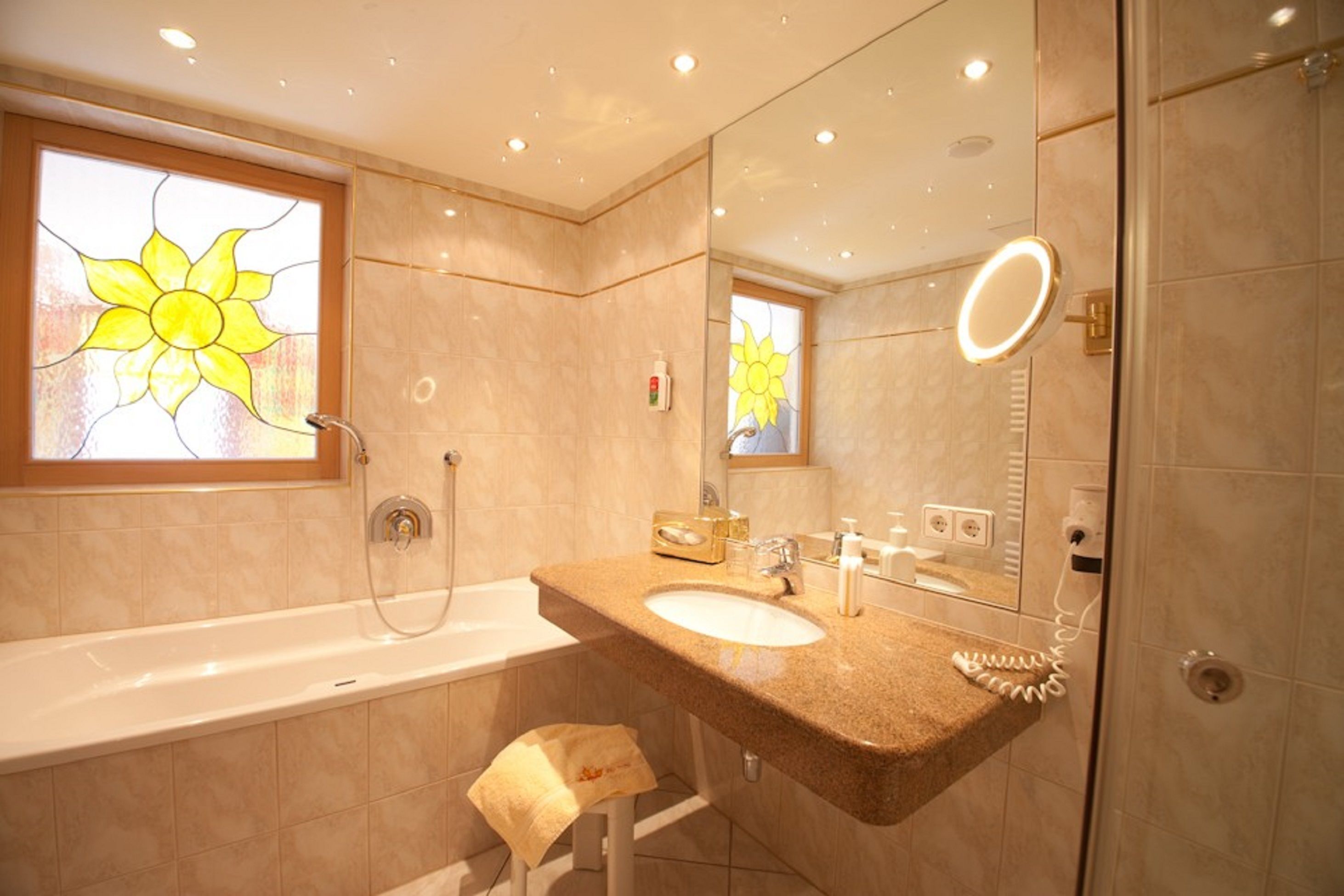 Un baño moderno con bañera, lavamanos y un espejo grande.