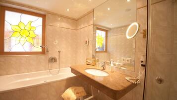 A modern bathroom with a bathtub, a sink, and a large mirror.