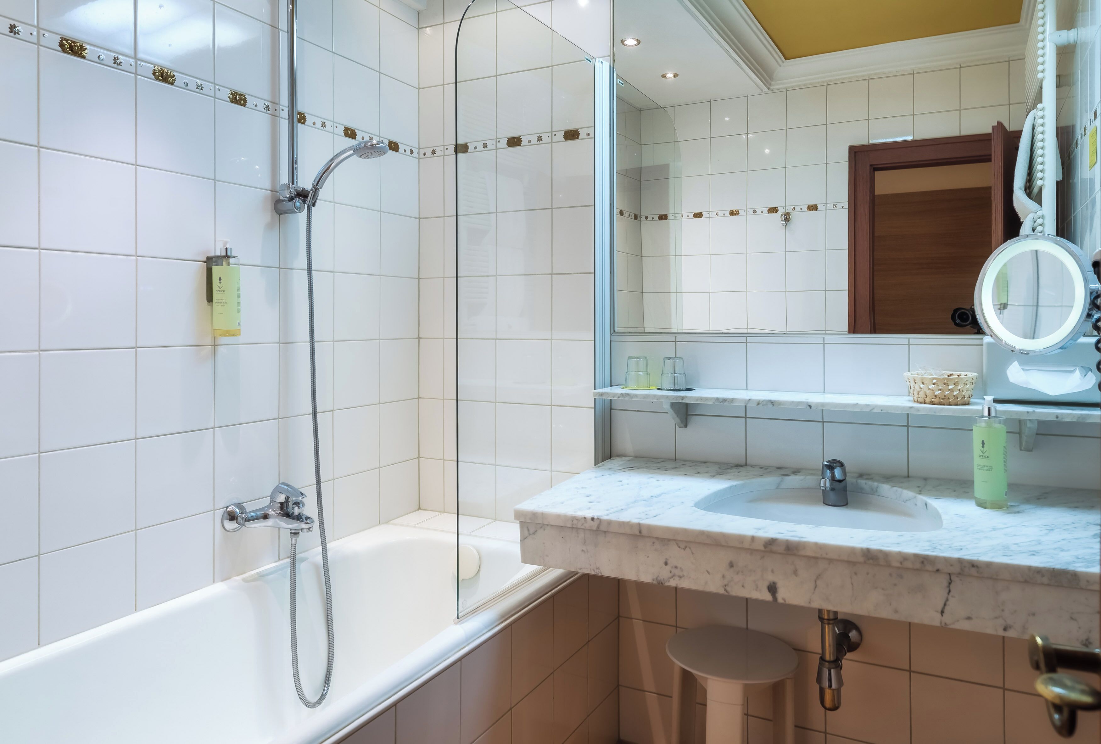 A modern bathroom with a bathtub, a shower, a sink, and a mirror.