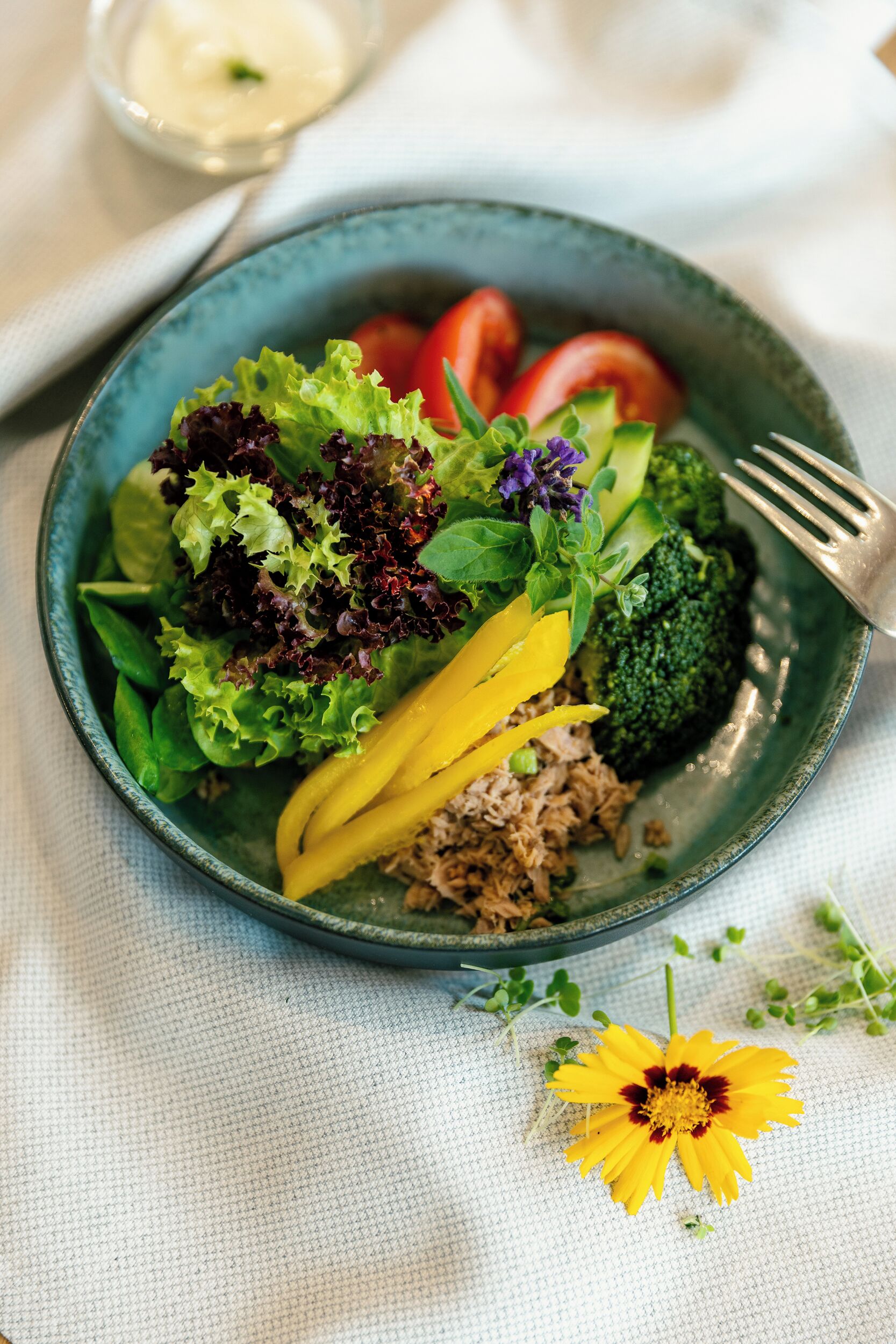 Une assiette de nourriture contenant divers légumes et une fleur.