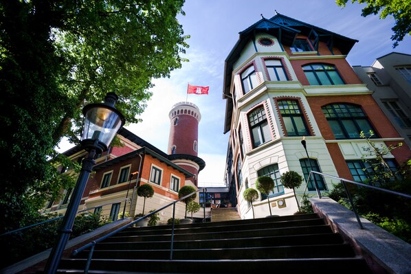 Un edificio con una torre, una bandera y una escalera.