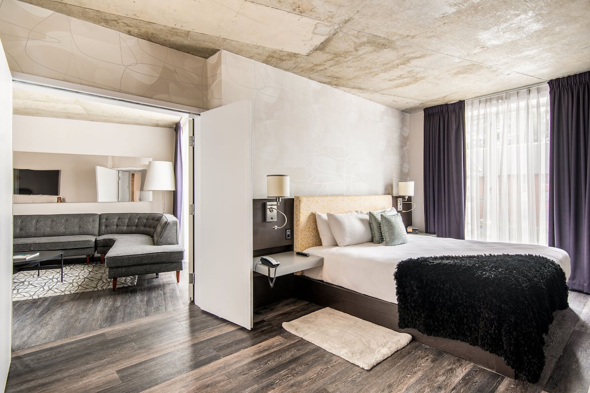 Une chambre d’hôtel moderne avec un grand lit, un canapé et un bureau.