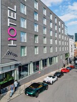 Egy modern dizájnnal rendelkező szálloda, amelynek homlokzatán feltűnő „HOTEL” felirat található.