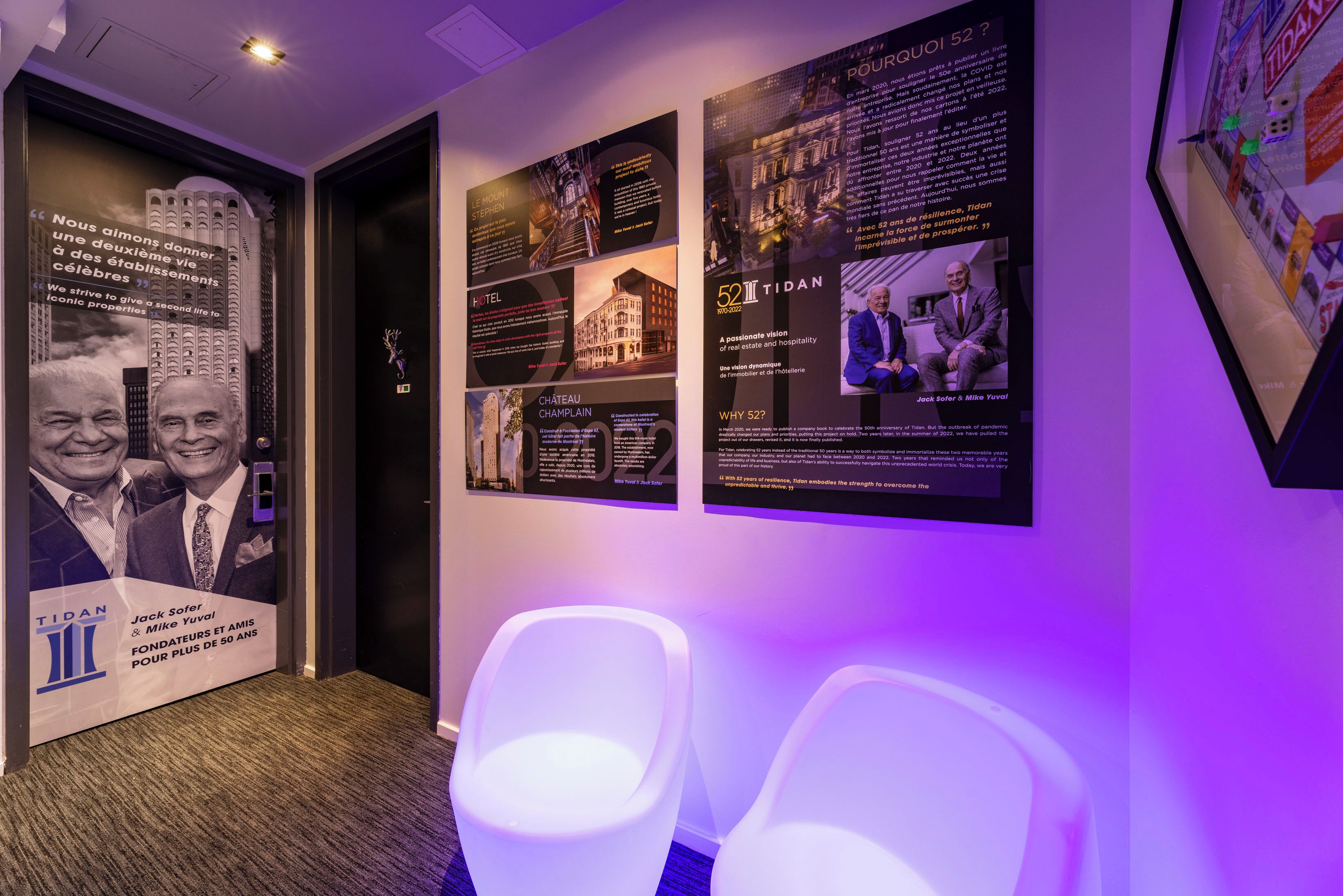 Un pasillo de hotel con carteles informativos, una zona de recepción y asientos.
